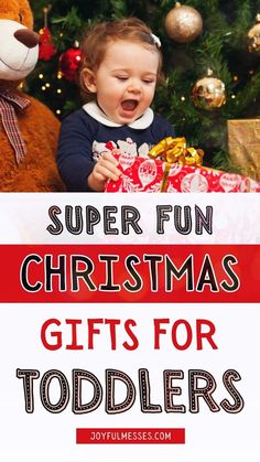 a baby holding a christmas present with the words super fun christmas gifts for toddlers