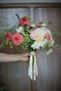 a woman holding a bouquet of flowers in her hand