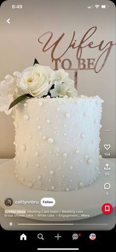 the cake is decorated with white flowers and pearls on it's icing, which reads wife to be