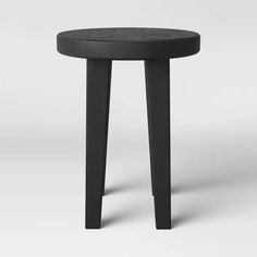 a small black stool sitting on top of a white floor