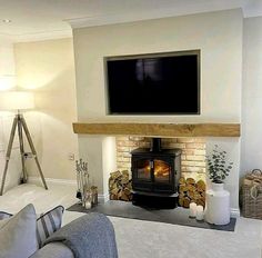 a living room filled with furniture and a flat screen tv mounted on the wall above a fire place