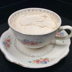 a white cup filled with cream sitting on top of a saucer