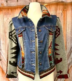 a denim jacket with an embroidered design on the front and back, sitting on a mannequin's head