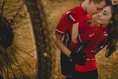 a man and woman embracing each other in front of a bike tire on the ground