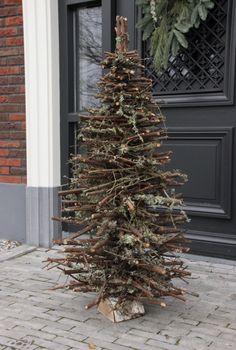 a small christmas tree sitting on the sidewalk