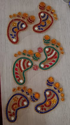 three pieces of beaded art work sitting on top of a table