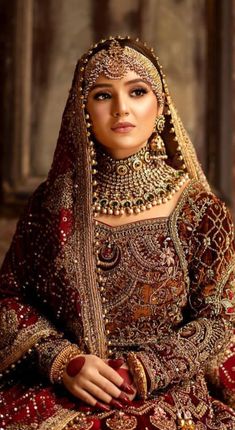 a woman in a red and gold bridal outfit