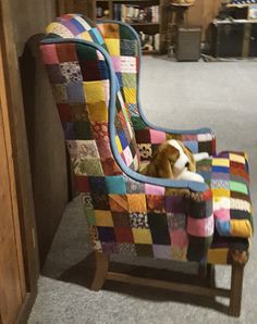 a dog laying on top of a patchwork chair in a room filled with furniture