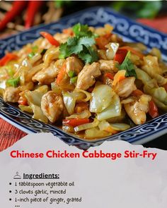 chinese chicken cabbage stir - fry on a blue and white plate with red chili peppers