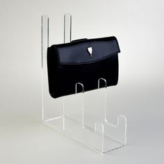 a black purse sitting on top of a metal holder