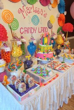 a candy land dessert table with lots of colorful candies and lollipops