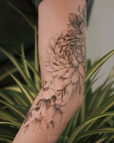 a woman's arm with a flower tattoo on it