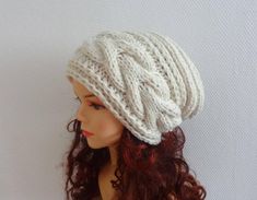 a mannequin head wearing a white knitted hat on top of a wig