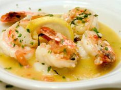 a white plate topped with shrimp and lemon