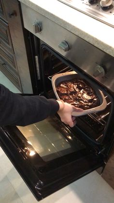 a person taking a dish out of an oven