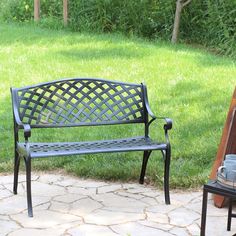 a metal bench sitting on top of a stone patio