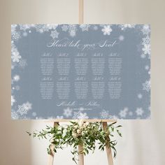 a blue and white wedding seating sign with snowflakes