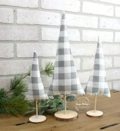 three small christmas trees sitting on top of a wooden table