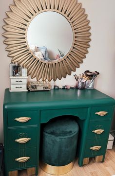 a green desk with a gold mirror above it