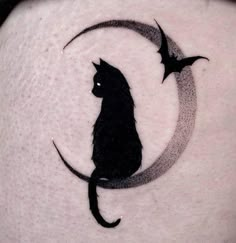 a black cat sitting on top of a crescent moon