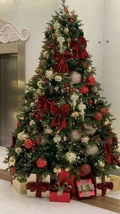 a christmas tree with presents under it in an office building, decorated for the holiday season