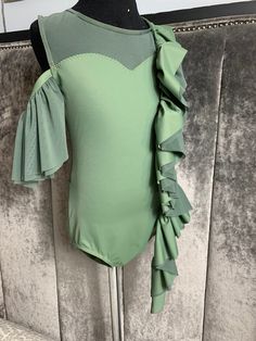 a green bodysuit with ruffled sleeves on a mannequin