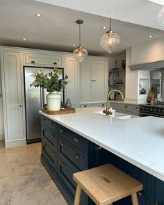 a large kitchen with an island counter top and stools in front of the sink