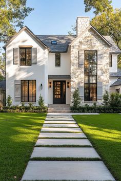 a white house with stone steps leading up to the front door and grass lawning