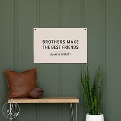 a sign that reads brothers make the best friends on a shelf next to a potted plant