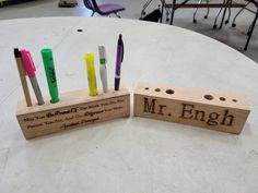 two wooden blocks with pens and markers on them