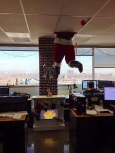 an office decorated for christmas with santa's hat and stockings hanging from the ceiling