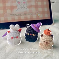 three crocheted animals sitting next to each other in front of a computer screen