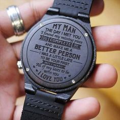 a person holding a wooden watch with the words i love you written on its face