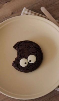 a chocolate cookie with googly eyes on a plate