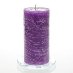 a purple candle sitting on top of a glass plate