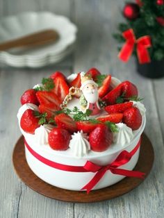 a white cake topped with strawberries on top of a wooden table