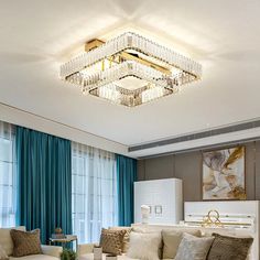 a living room filled with furniture and a chandelier hanging from the ceiling above it