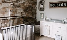 a baby's room with a crib and stone wall