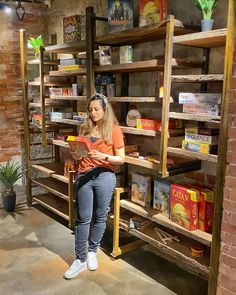 a woman standing in front of a shelf filled with books