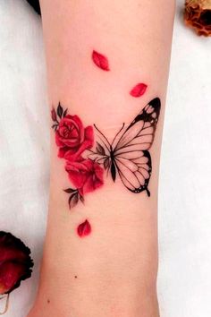 a woman's foot with a butterfly and roses tattoo on it