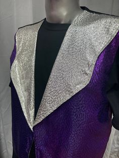 a purple and silver jacket on a mannequin's head with a black shirt underneath it