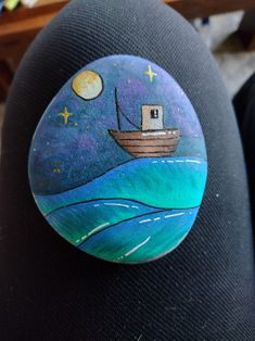 a painted rock with a boat on it