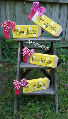 three wooden signs with bows on them sitting in the grass