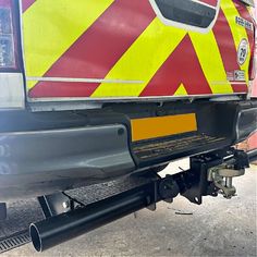 the rear end of a vehicle with yellow and red stripes