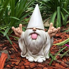 a gnome statue sitting on the ground with his tongue out and hands in the air