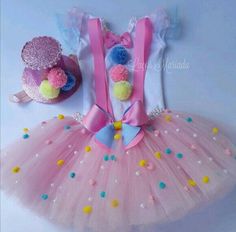 a pink tutu skirt with pom - poms on it and a hat