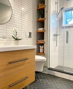 a bathroom with a sink, toilet and shower stall in the corner next to a walk - in shower