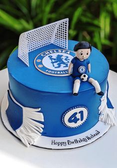 a birthday cake for a soccer player with a goalie figurine on top