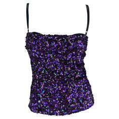 Presenting a fantastic purple sequin Dolce and Gabbana top. From the Fall/Winter 2000 collection, this top debuted on one of the season's runways. This fabulously shimmery top is covered in hues of purple sequins, with a few green sequins scattered throughout to create texture. This chic top is made complete with Dolce & Gabbana's signature built-in lace bra. Approximate measurements: Size - 40IT Shoulder to hem: 22" Bust: 30" - 34" Waist: 26" - 30" 100% Polyester Fitted Purple Sequin Top, Glamorous Purple Sequin Top, Purple Embellished Sleeveless Top, Glamorous Purple Party Tops, Purple Evening Tops For Party Season, Purple Top For Evening And Party Season, Purple Tops For Evening Party Season, Purple Tops For Evening And Party Season, 2000s Brands