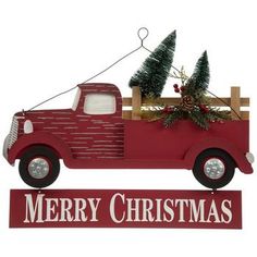 a red truck with a christmas tree in the back and merry christmas sign above it